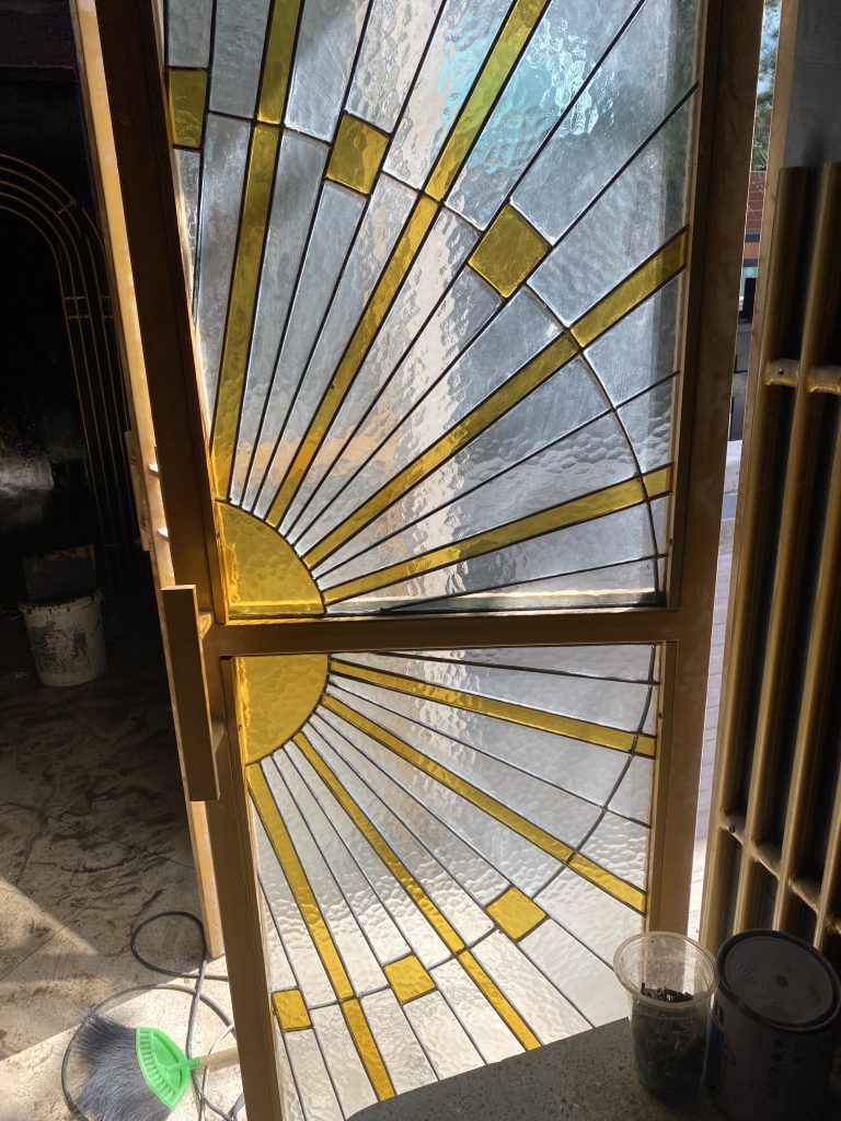 stained glass sun installation on a metal door frame in restaurant in canggu area, bali