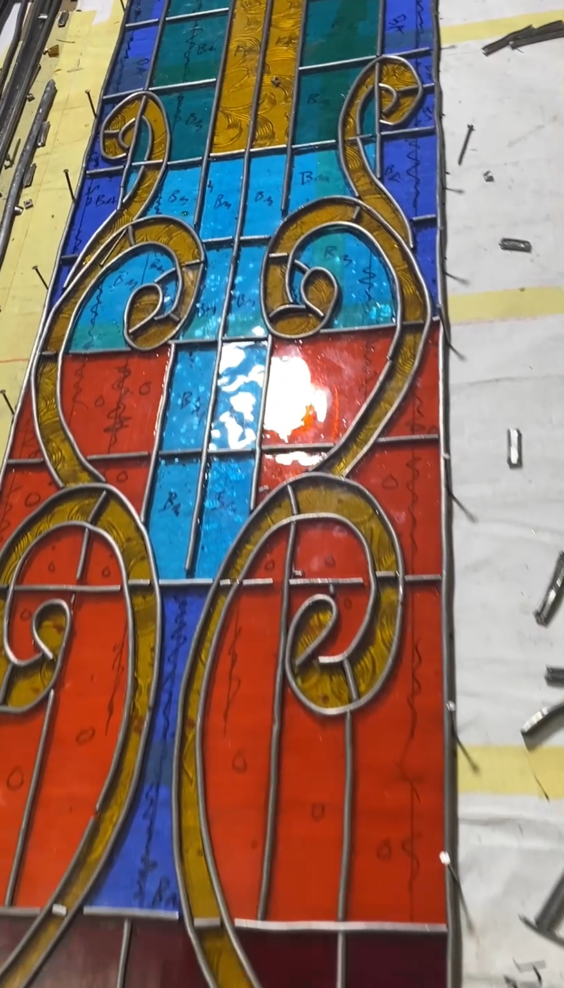 Close-up of the imported American stained glass showing the light blue, orange, and bloody red colors.